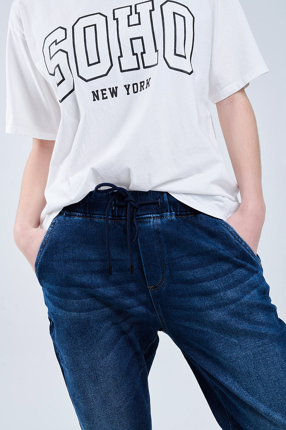 Jeans a lavaggio scuro con bordatura ed elastico in vita