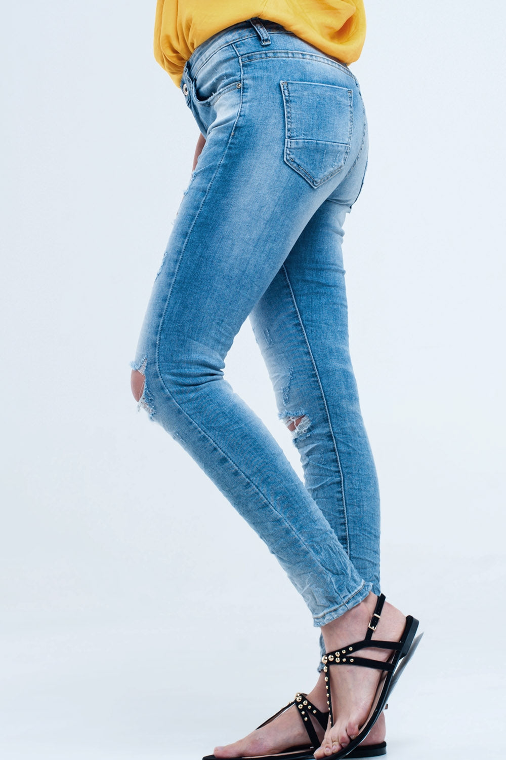 Jeans skinny a metà lavaggio con strappi al ginocchio