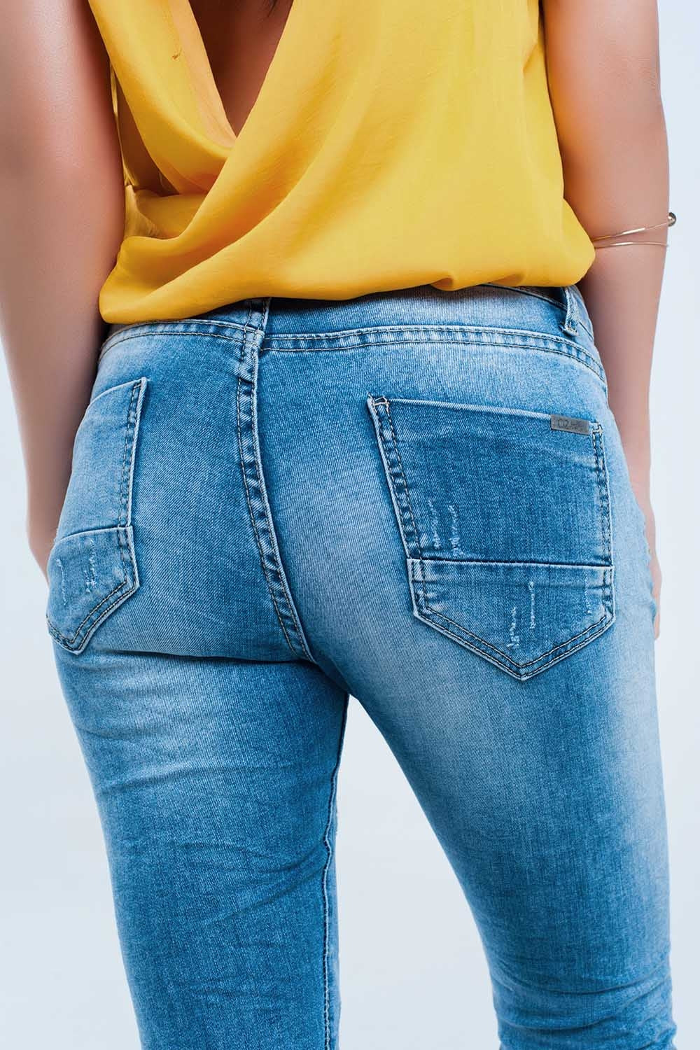 Jeans skinny a metà lavaggio con strappi al ginocchio