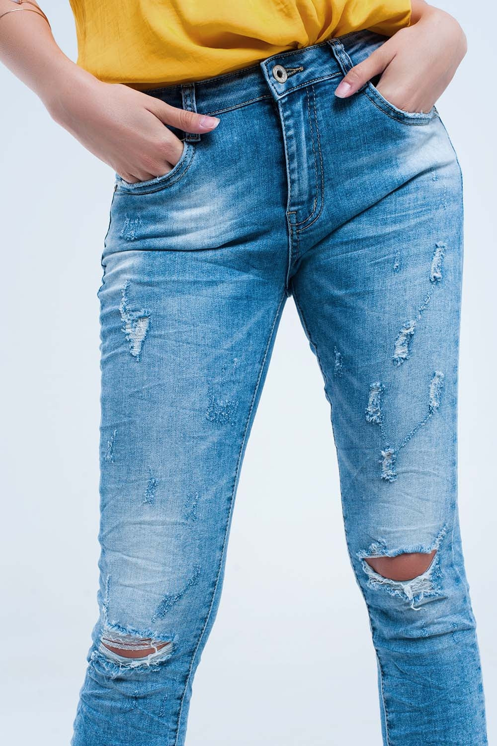 Jeans skinny a metà lavaggio con strappi al ginocchio