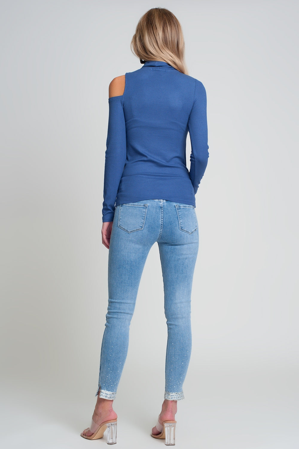 Maglione blu con una spalla scoperta e collo alto