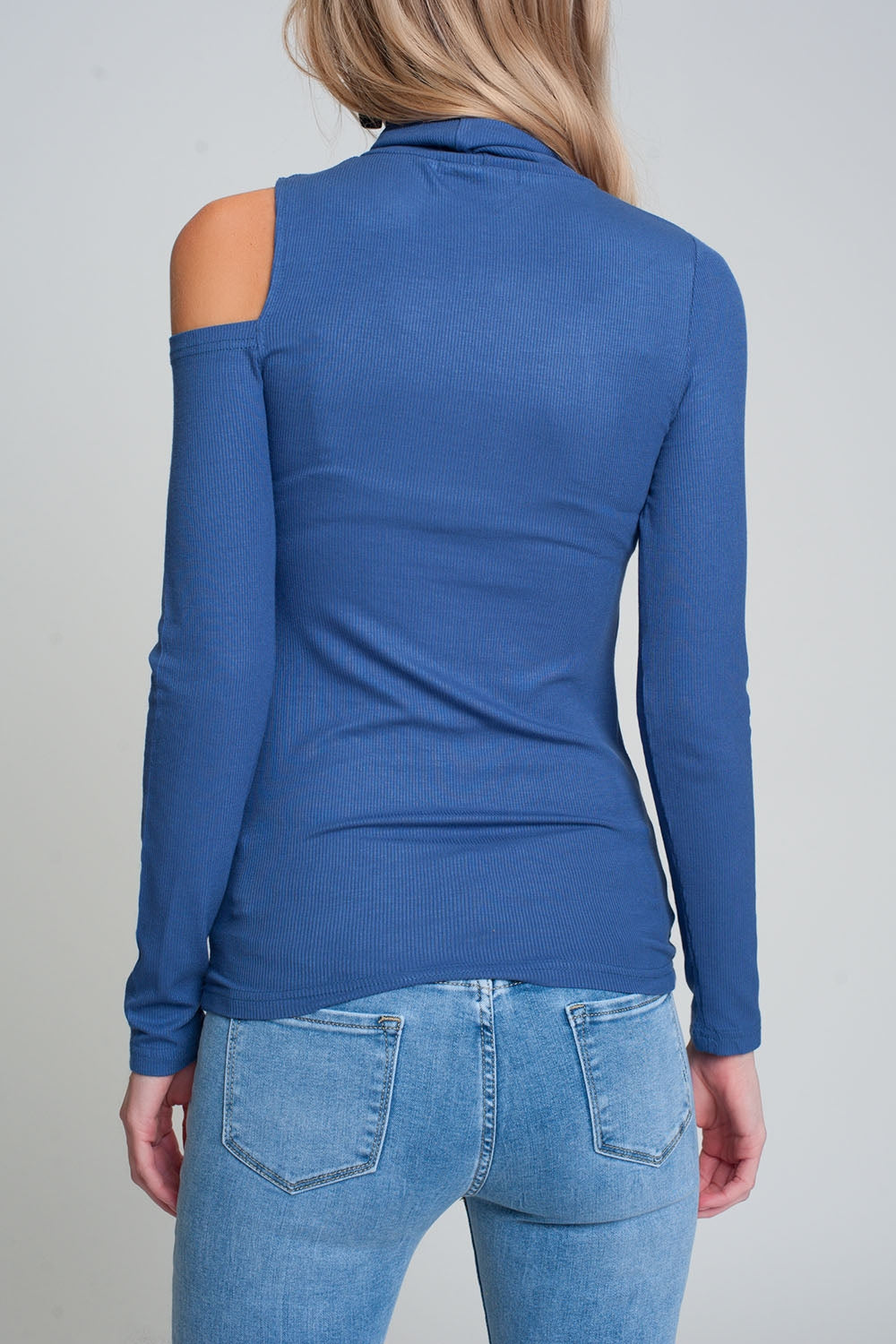 Maglione blu con una spalla scoperta e collo alto