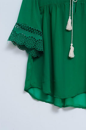 Blusa con finiture in pizzo allacciata sul davanti verde