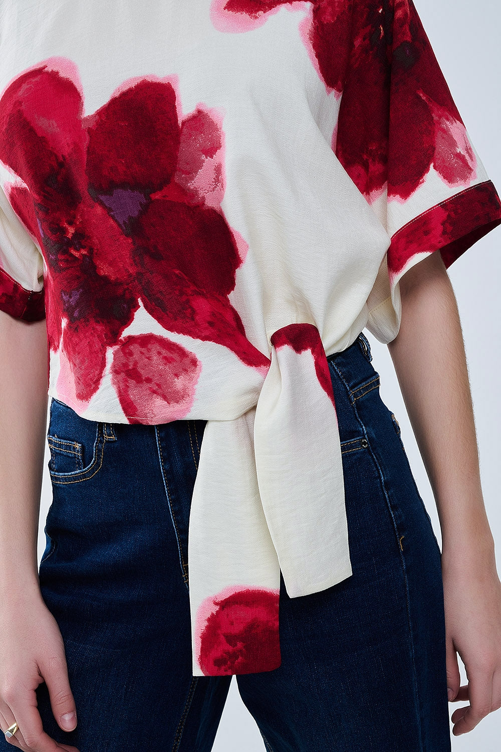 Camicetta cropped beige con stampa floreale tropicale in rosso legata in vita