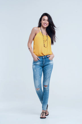 Jeans skinny a metà lavaggio con strappi al ginocchio