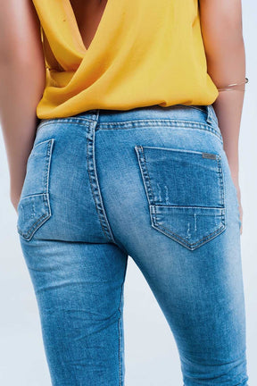 Jeans skinny a metà lavaggio con strappi al ginocchio