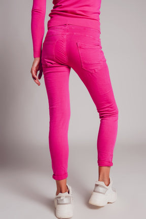 Jeans skinny con bottoni a vista e lavaggio fucsia