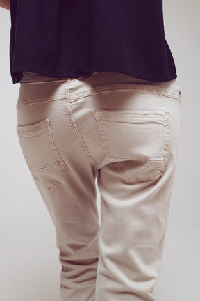 Jeans skinny con bottoni esposti in beige