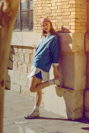 Maglione sciolto a maglia fine di colore blu con scollo rotondo