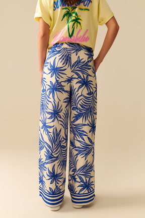 Pantaloni a gamba larga bianchi con stampa tropicale blu