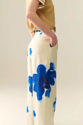 Pantaloni palazzo bianchi con stampa floreale tropicale blu e cintura abbinata