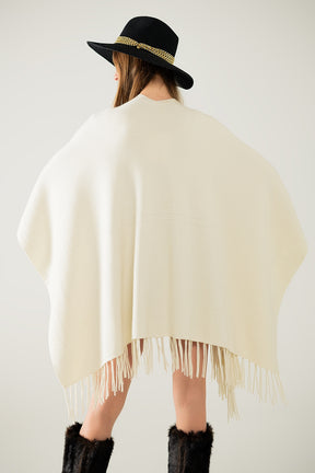 Poncho in morbida maglia beige con frange