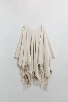 Poncho in morbida maglia beige con frange
