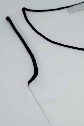 Top bianco senza maniche con scollo a girocollo e bordi neri