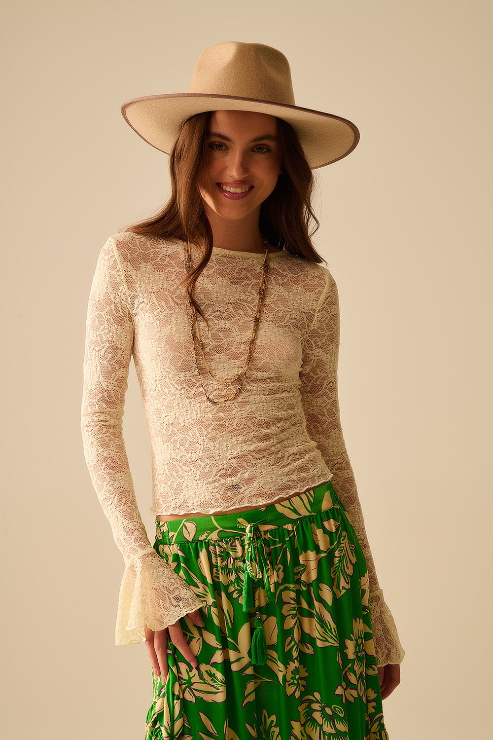 Top di pizzo color crema con maniche lunghe svasate e volant