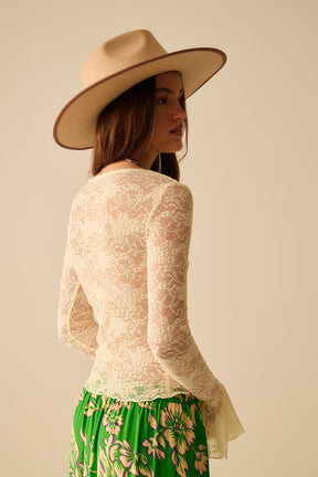Top di pizzo color crema con maniche lunghe svasate e volant