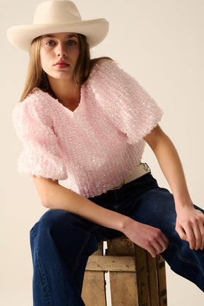 Top rosa con dettagli di paillettes e maniche a palloncino